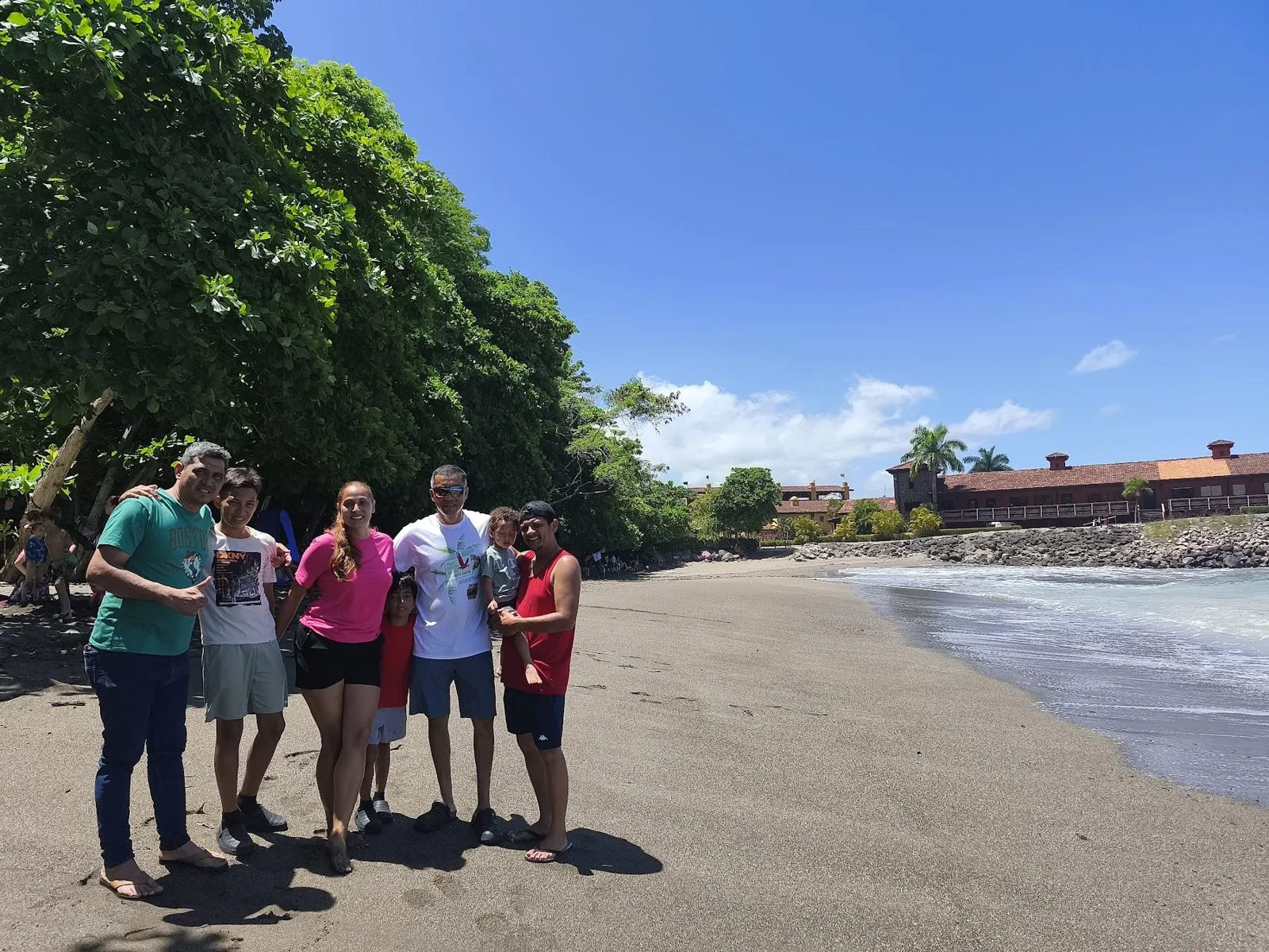 A group of travelers posing on a sunny beach