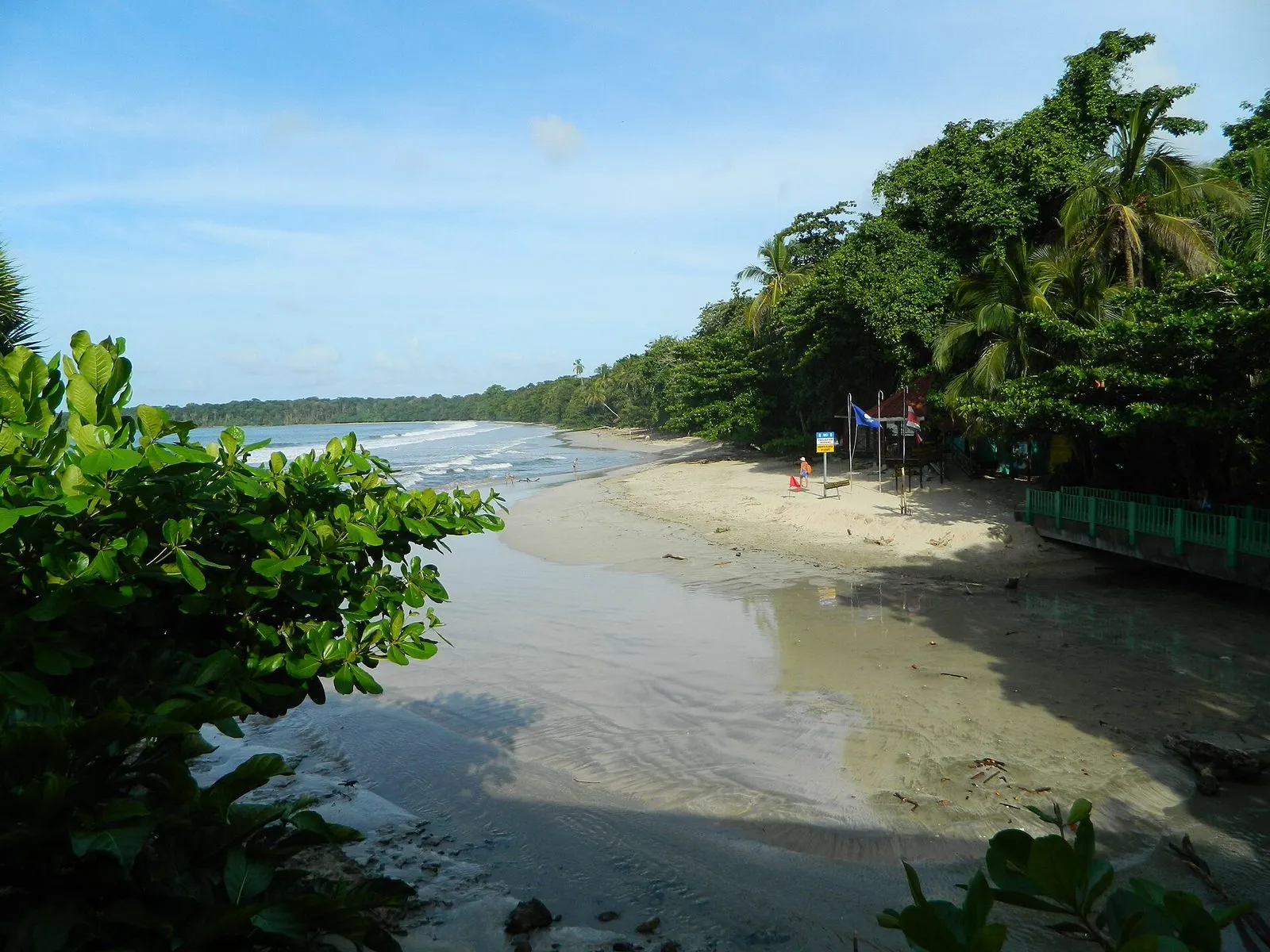 Palm-lined beach and calm Caribbean water at the entrance to Cahuita National Park