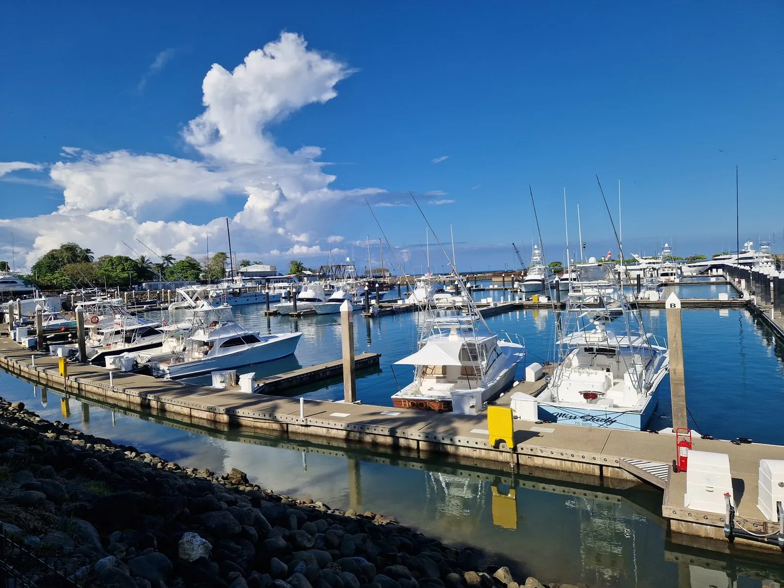 Boats moored at Marina Pez Vela in Quepos under a blue sky