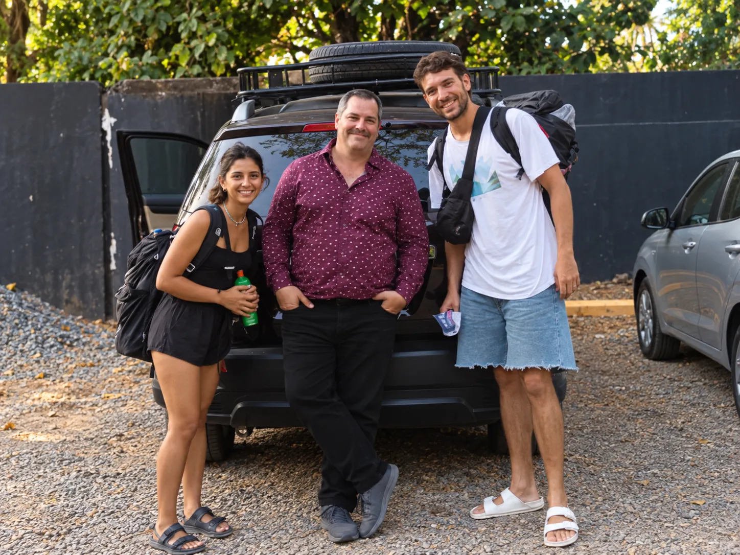 Gonzalo Roffo with two travelers next to his car