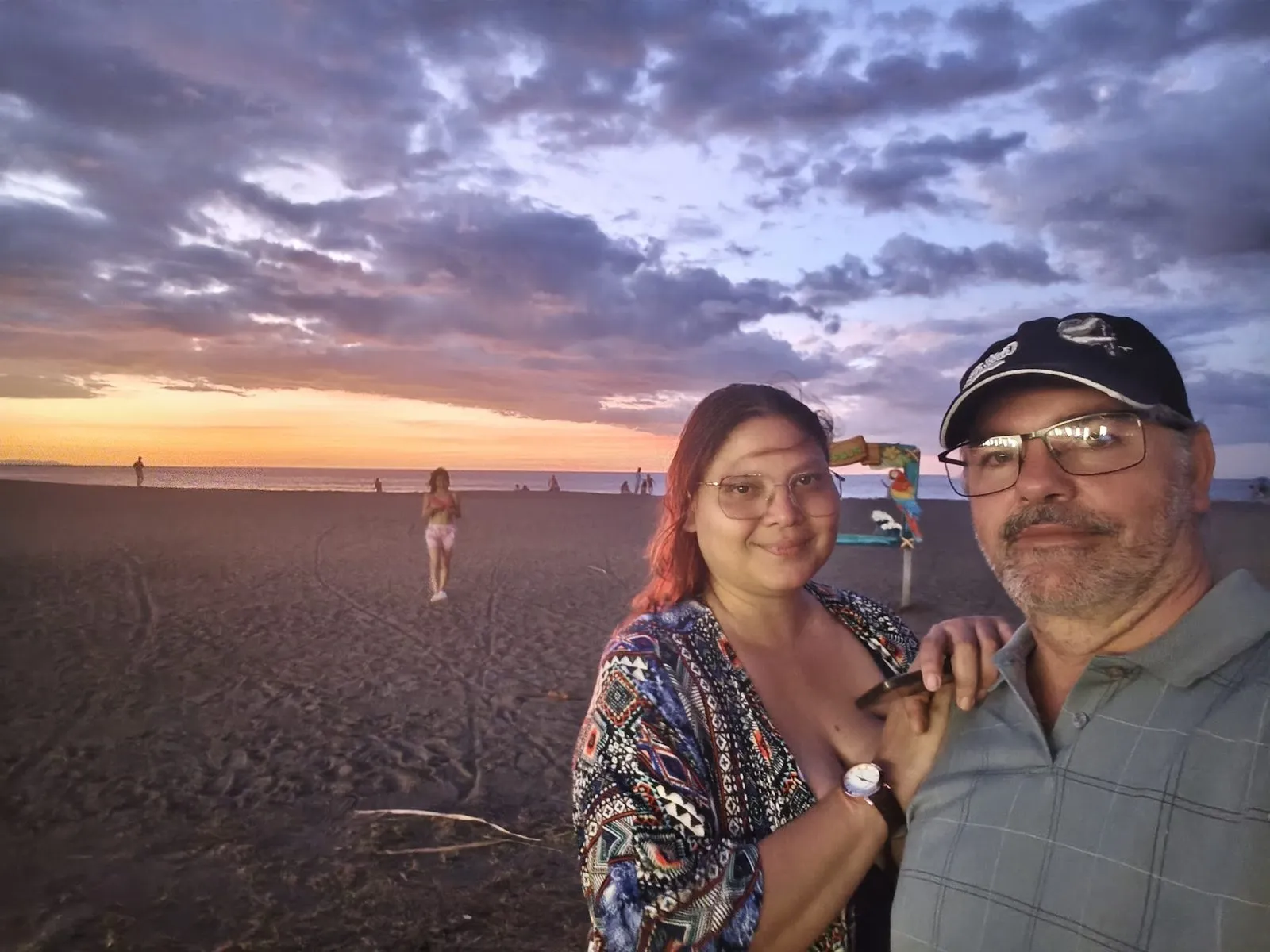 Two travelers on Jacó beach at sunset