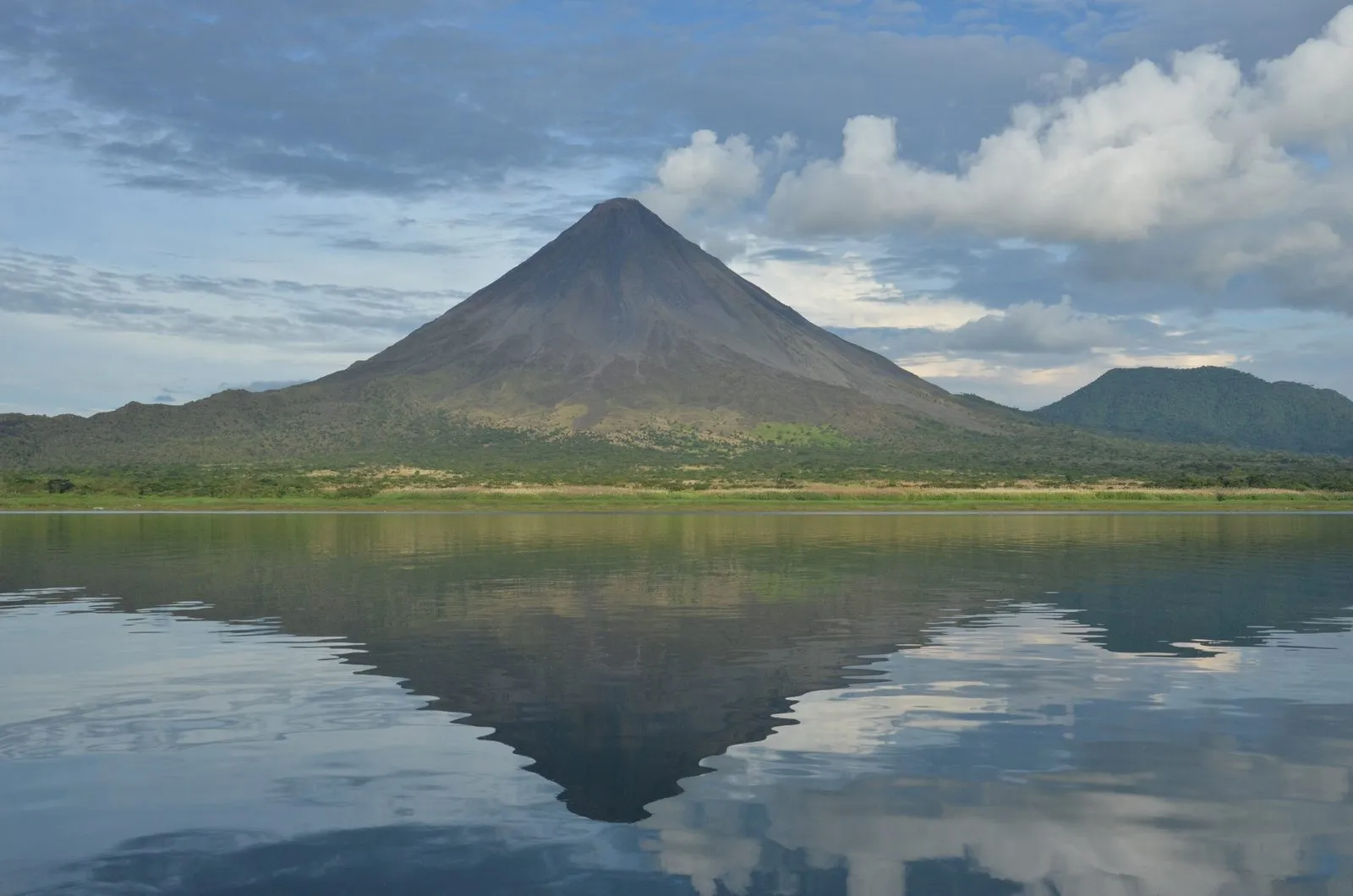 Arenal Volcano reflected in the calm waters of Lake Arenal.